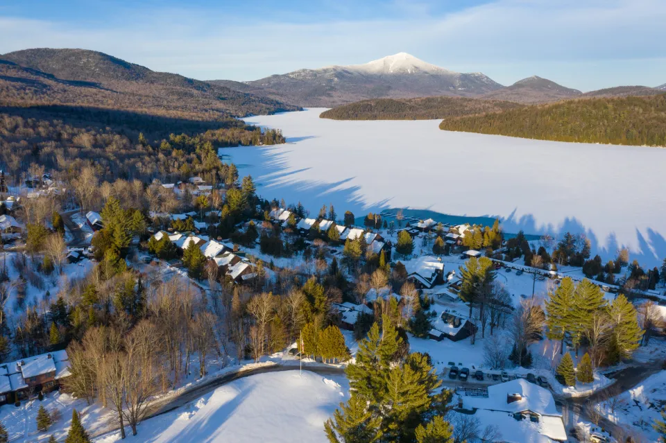 An aerial view of Lake Placid in winter with Whiteface Mountain in the background